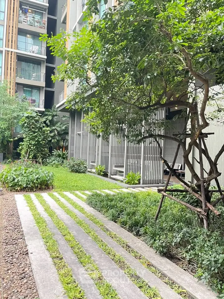 Modern apartment building with lush garden and green landscaping