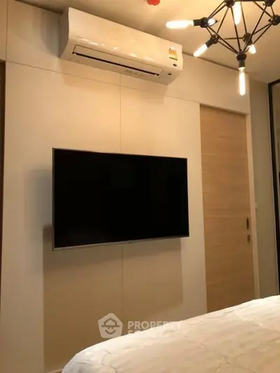 Modern bedroom with wall-mounted TV and air conditioning unit