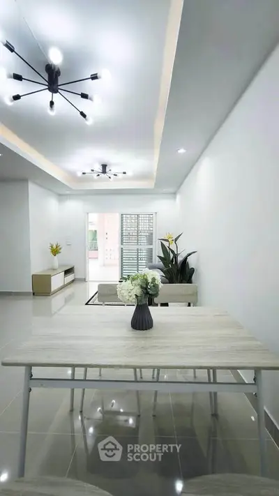 Modern living room with sleek lighting and minimalist decor, featuring a stylish table and comfortable seating.