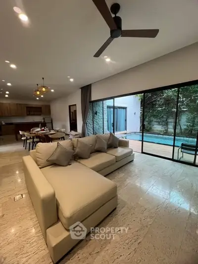 Spacious living room with pool view, modern furniture, and open layout in luxury home.