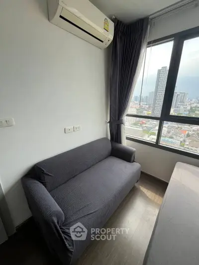 Modern apartment with city view, featuring a cozy sofa and air conditioning.