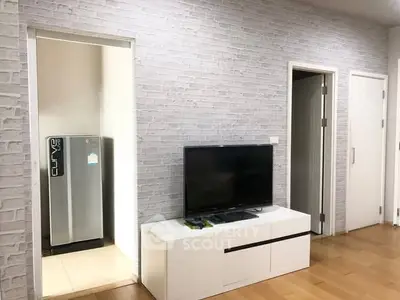 Modern living room with TV and sleek refrigerator in open layout