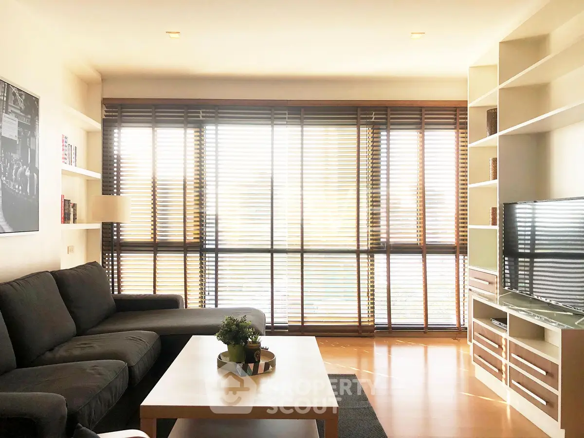 Spacious living room with modern furniture and large windows offering natural light.