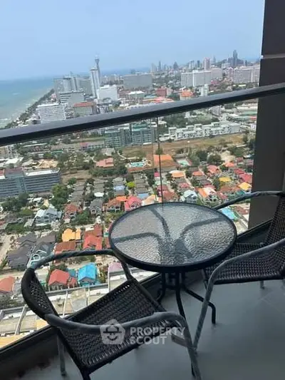 Stunning high-rise balcony view with cityscape and ocean panorama.