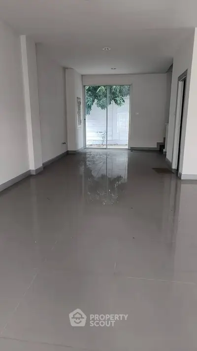 Spacious empty room with large windows and glossy tiled floor