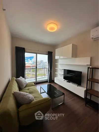 Modern living room with stylish furniture and city view balcony in a high-rise apartment.