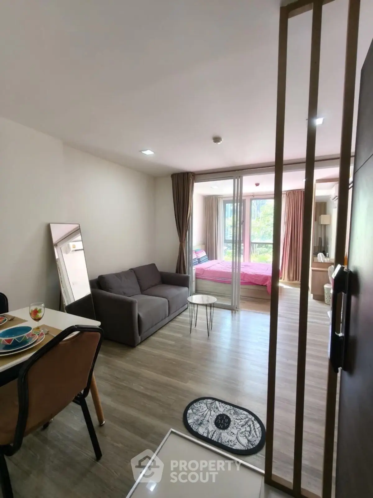Modern open-plan living room with cozy seating and natural light in a stylish apartment.