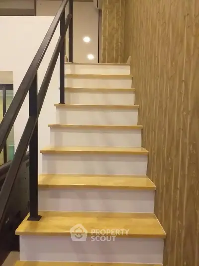 Modern wooden staircase with sleek railing in contemporary home interior