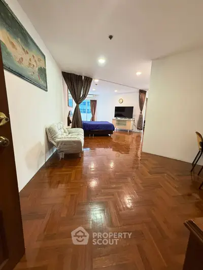 Spacious open-layout living area with wooden flooring and modern decor