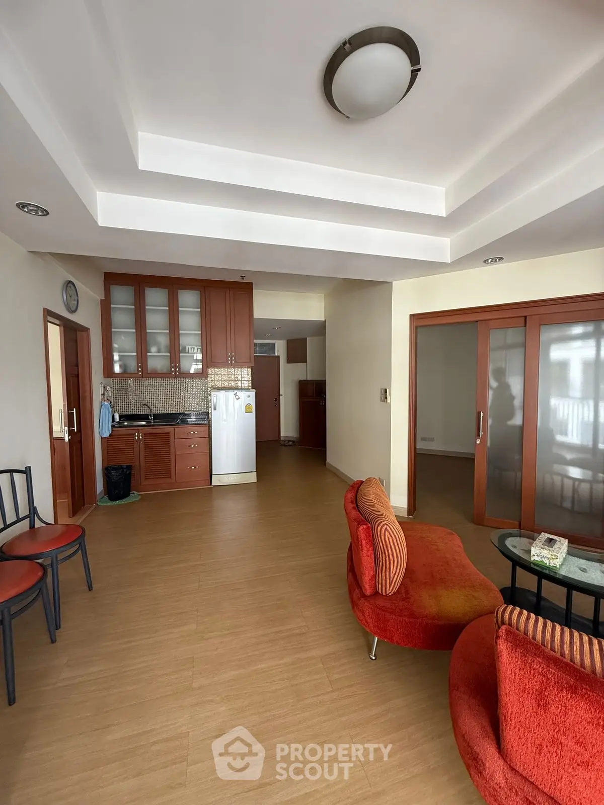 Spacious living room with modern kitchen and stylish red seating