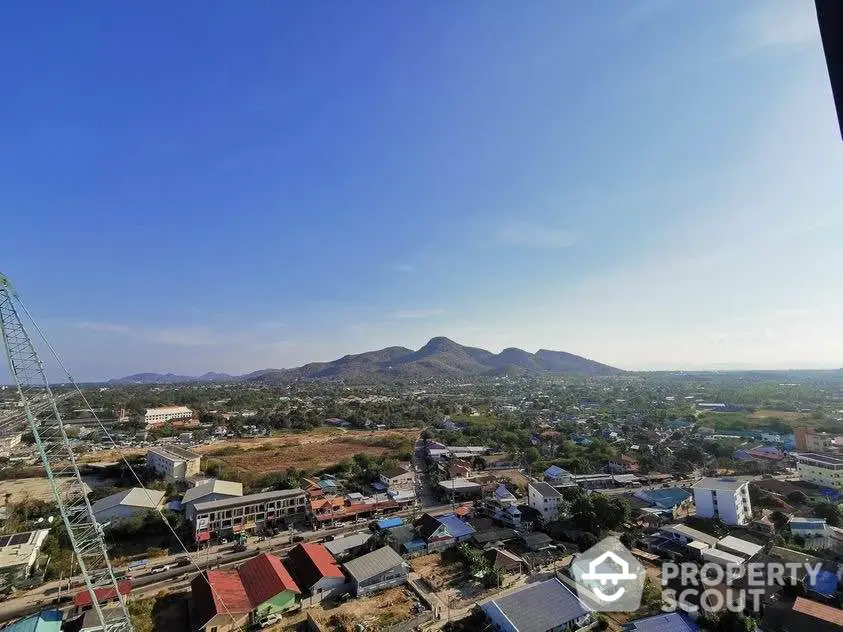 Stunning panoramic view of a vibrant town with mountains in the background, perfect for real estate investment.