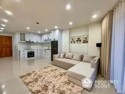 Spacious modern living room with open kitchen layout and cozy sofa