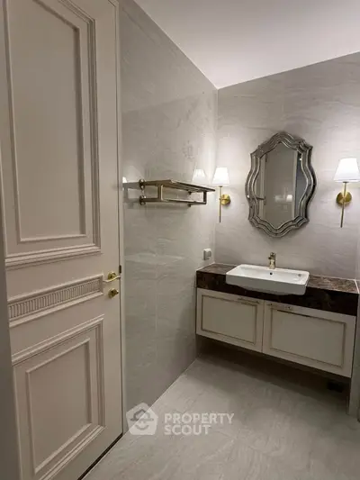Elegant bathroom with stylish mirror and modern fixtures in luxury real estate property.