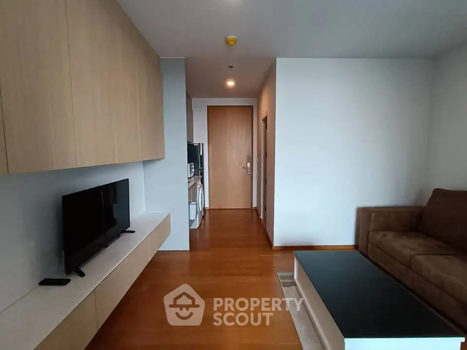 Modern living room with sleek wooden flooring and minimalist furniture design.