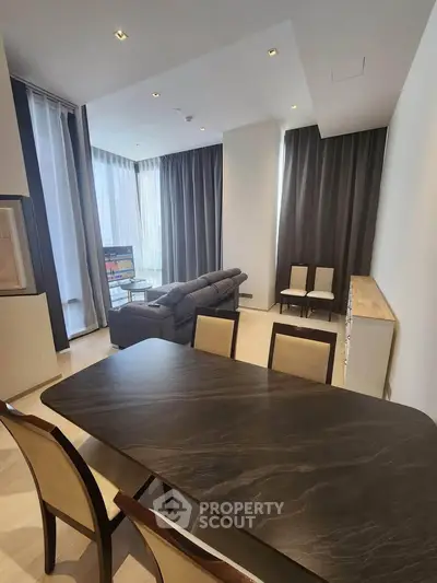 Luxurious modern living room with elegant dining area and large windows offering natural light.