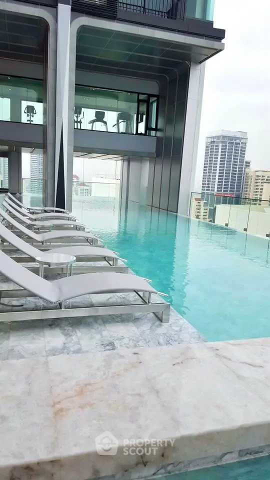 Luxurious rooftop infinity pool with city skyline views and modern lounge chairs.