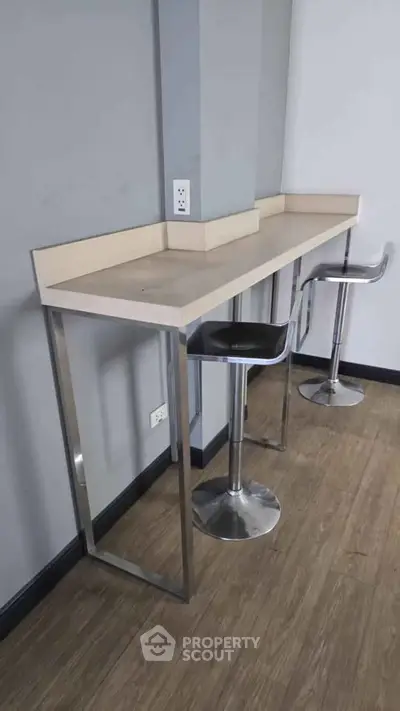 Modern minimalist bar counter with sleek stools in a stylish interior space.