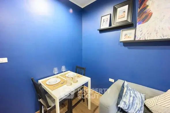 Cozy dining nook with vibrant blue walls and modern decor in a stylish apartment.
