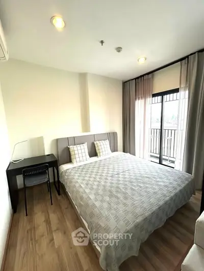 Modern bedroom with balcony access and stylish decor in a cozy apartment.