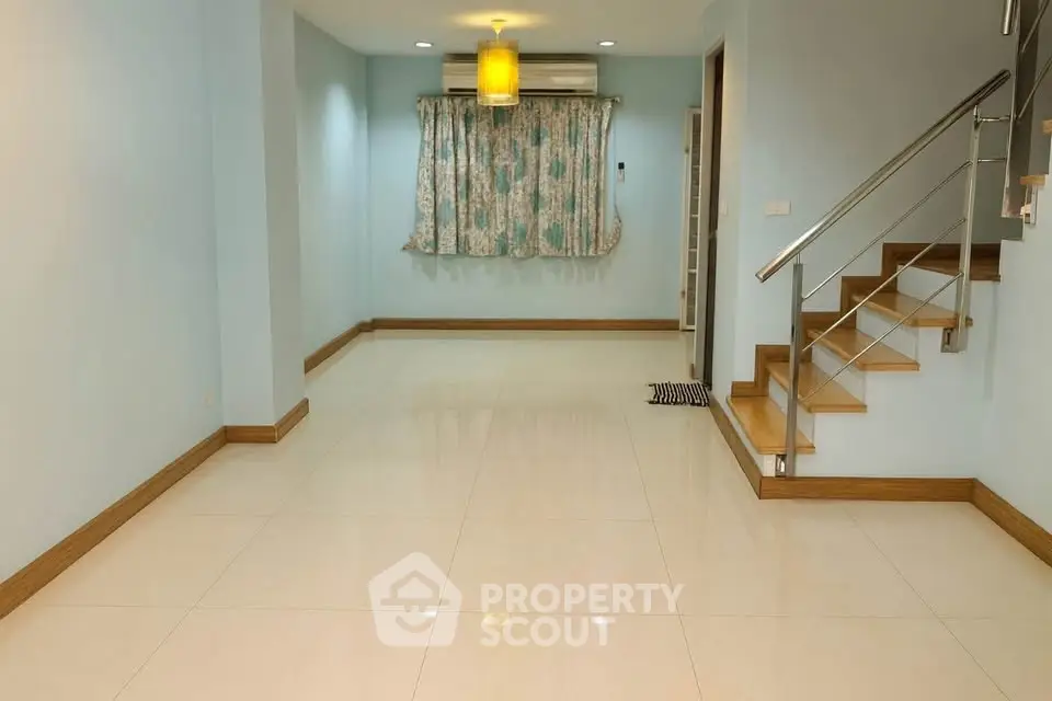 Spacious living room with modern staircase and elegant lighting