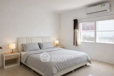 Bright and airy bedroom with modern furnishings and large window offering natural light.