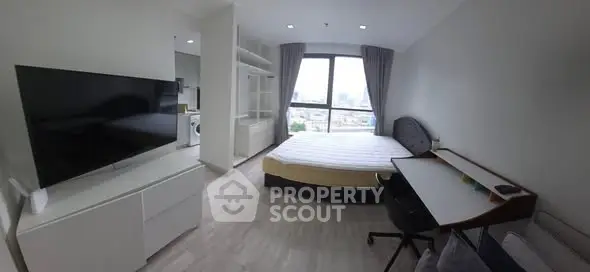 Modern bedroom with large window and study area in a city apartment.