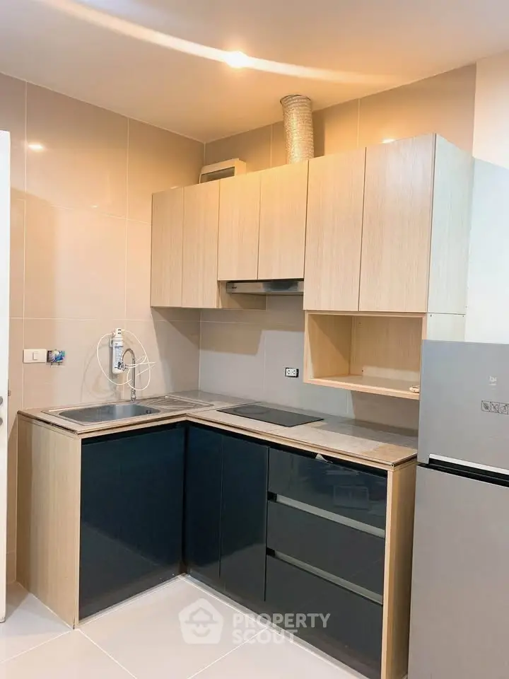 Modern kitchen with sleek cabinetry and stainless steel appliances in a compact layout.
