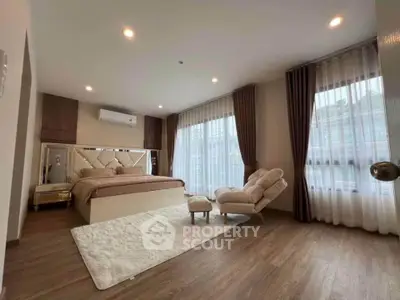 Luxurious bedroom with elegant decor and large windows offering natural light