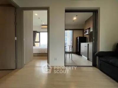 Modern apartment interior with open layout connecting living room, bedroom, and kitchen.