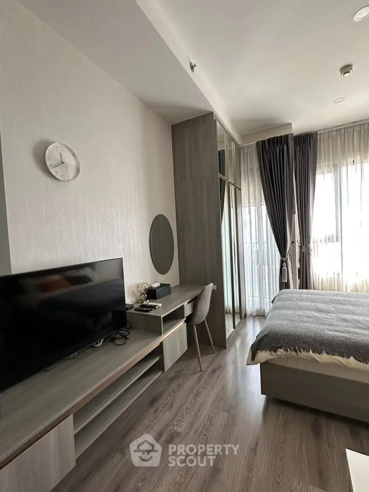 Modern bedroom with sleek design, featuring a large window, stylish furniture, and a cozy atmosphere.