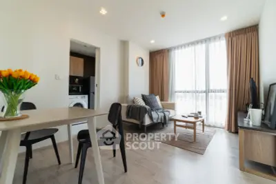 Modern living room with natural light, cozy seating, and stylish decor in a contemporary apartment.