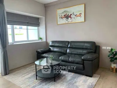 Modern living room with black leather sofa and stylish decor