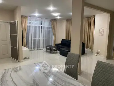 Spacious modern living room with elegant marble dining table and cozy seating area.