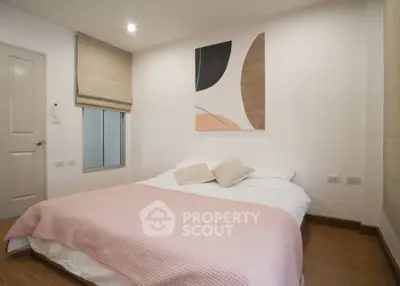 Cozy bedroom with modern decor and soft lighting, featuring a comfortable bed and stylish wall art.