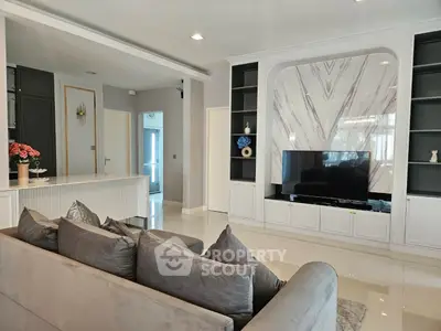 Luxurious modern living room with elegant decor and large TV, perfect for relaxation and entertainment.