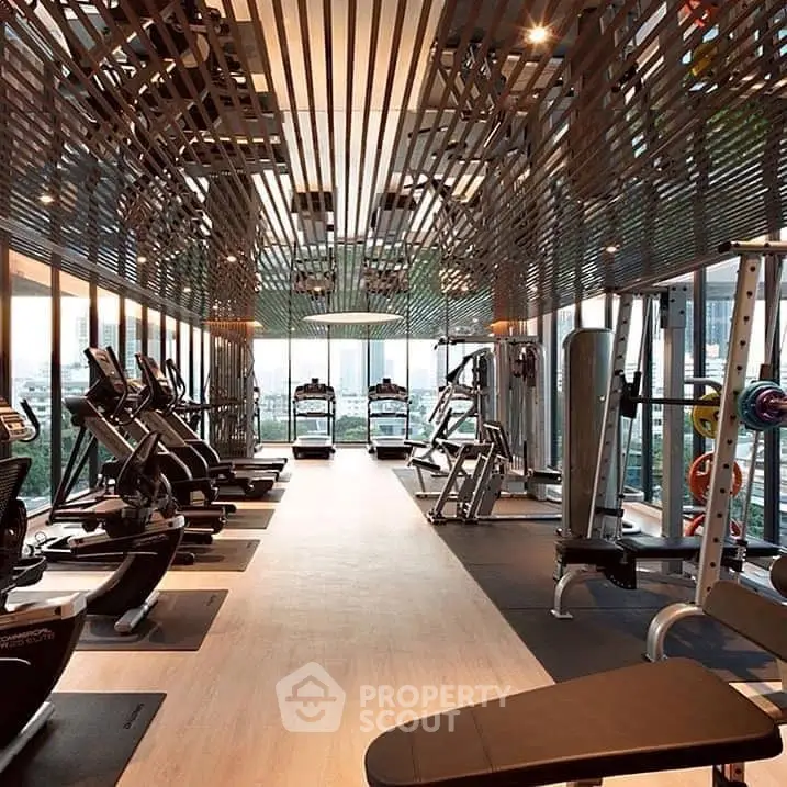 Luxurious gym with modern equipment and panoramic city views in a high-end residential building.