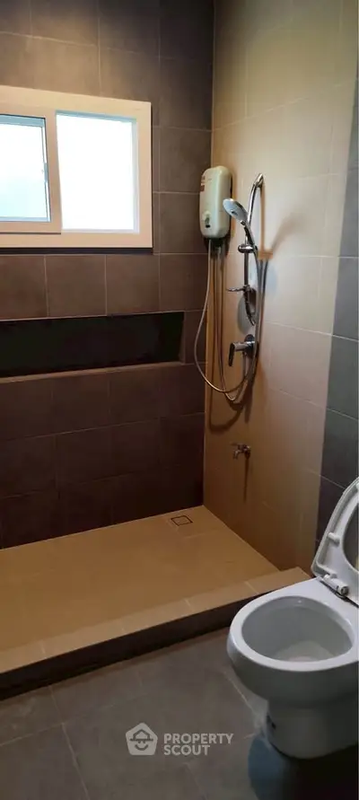 Modern bathroom with sleek shower and toilet in contemporary design.