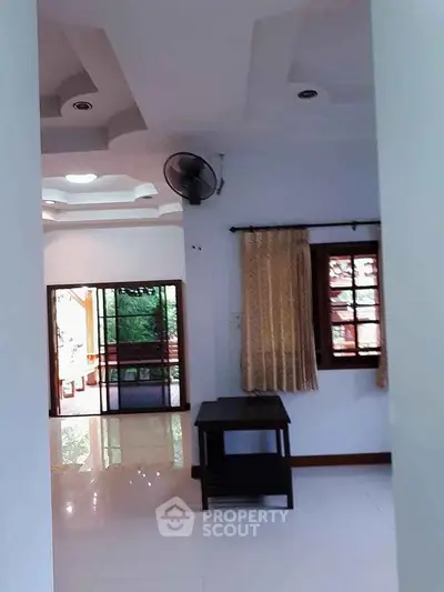 Spacious living area with large windows and natural light, ideal for family gatherings.