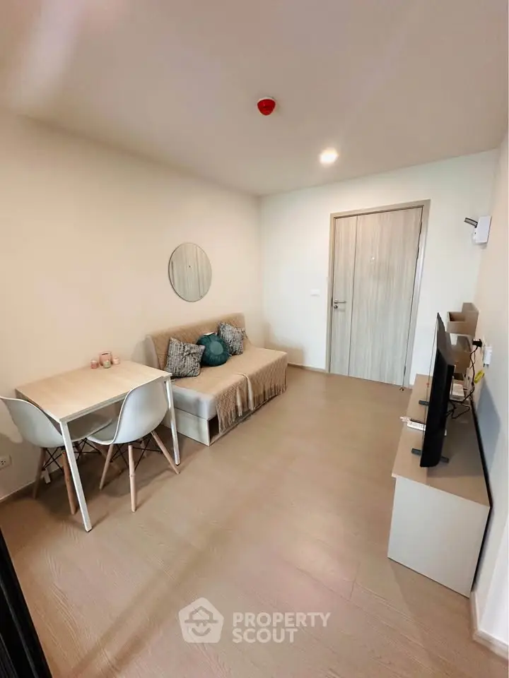 Modern living room with cozy sofa, dining table, and flat-screen TV in a stylish apartment.