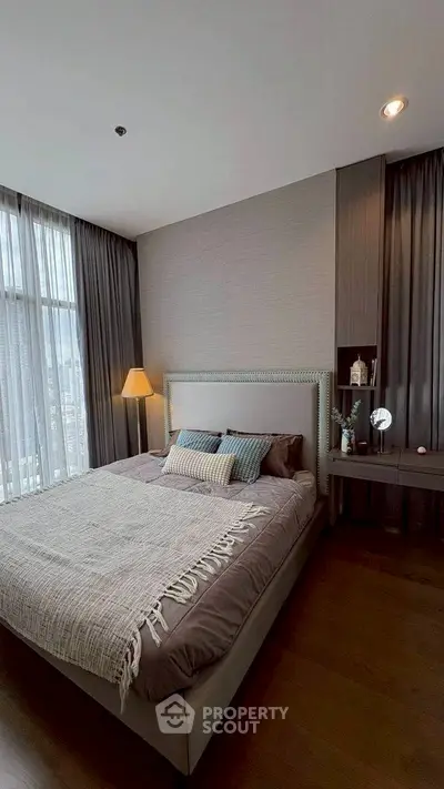 Luxurious bedroom with elegant decor and large windows offering city views.