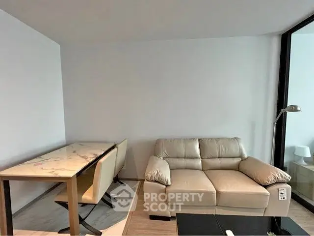 Modern living room with elegant marble dining table and cozy beige sofa, perfect for urban living.