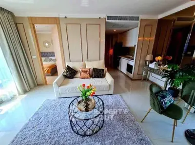 Luxurious modern living room with elegant decor and open kitchen layout, featuring plush seating and stylish accents.