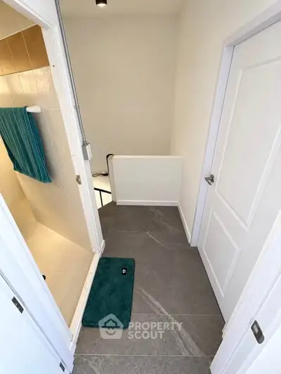 Modern hallway with sleek tile flooring and bathroom access, ideal for contemporary living spaces.