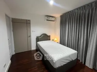 Cozy bedroom with single bed, elegant curtains, and warm lighting, perfect for restful nights.