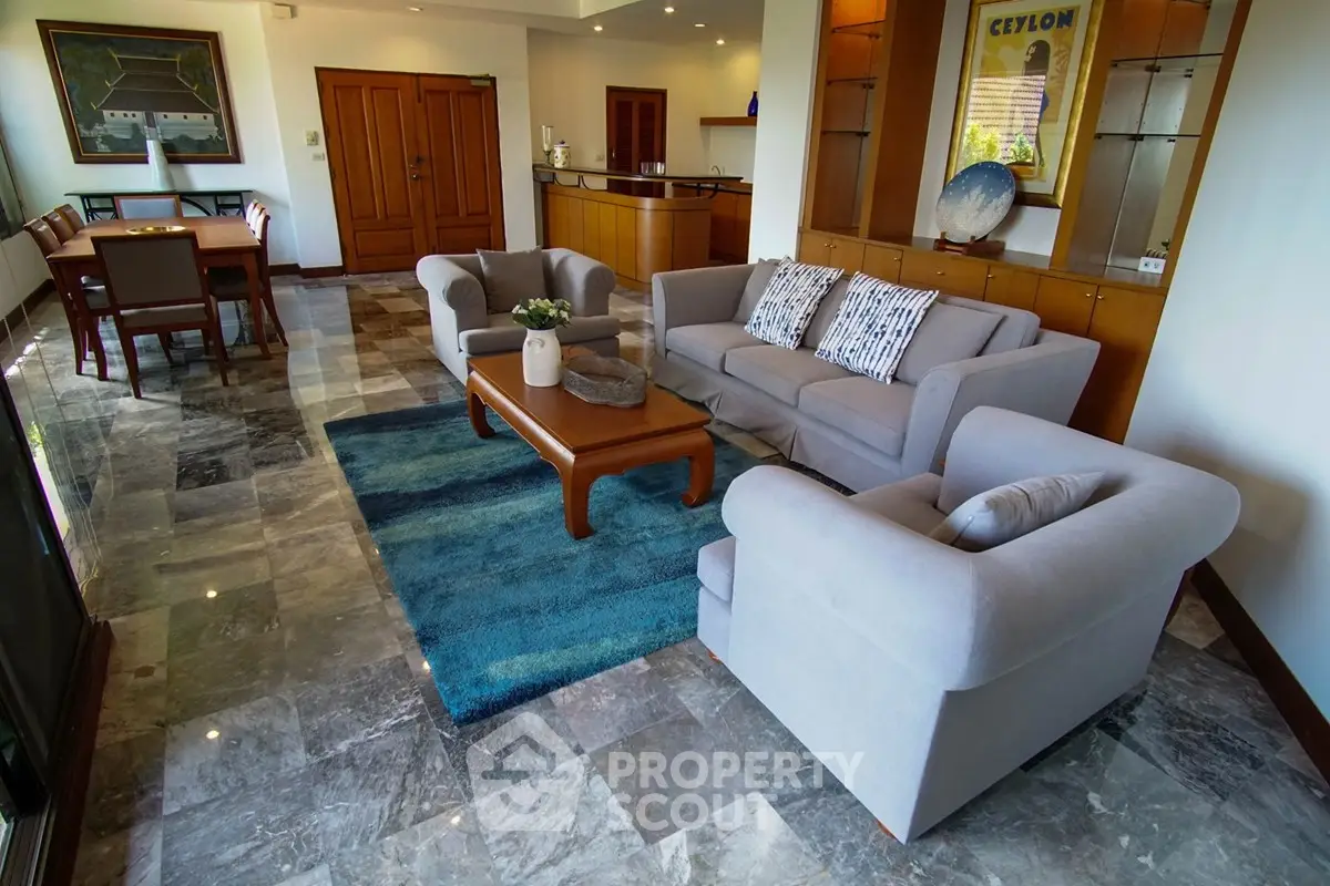 Spacious living room with elegant furniture and marble flooring in a modern home.
