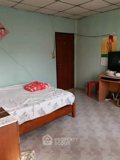 Cozy bedroom with simple furnishings and tiled floor, ideal for minimalist living.