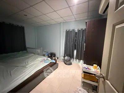 Cozy bedroom with tiled flooring and ample natural light from large windows.