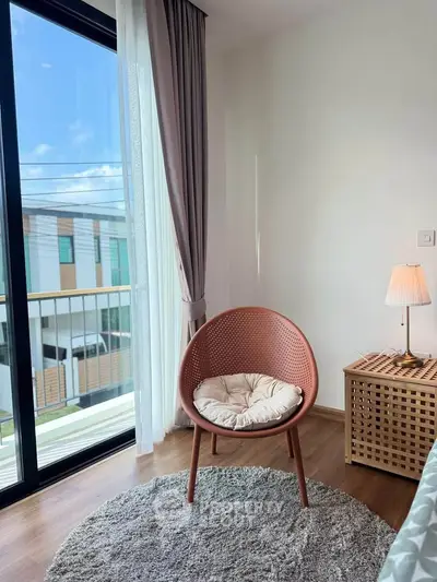 Cozy corner with modern chair and lamp by a large window in a stylish apartment.