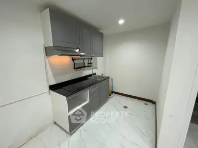 Modern kitchen with sleek cabinetry and marble flooring in a compact layout.