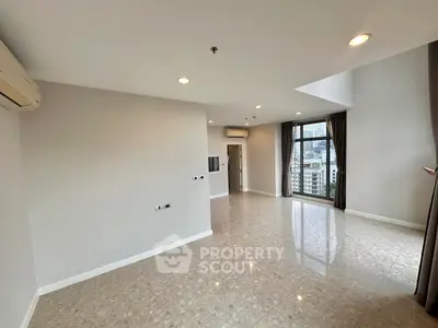 Spacious modern living room with large windows and city view, perfect for urban living.